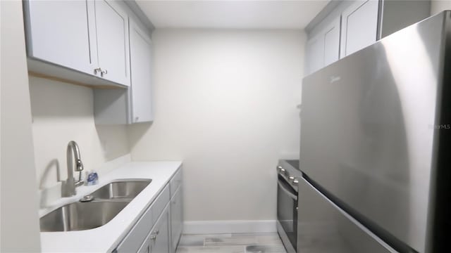 kitchen featuring sink, stainless steel refrigerator, and stove