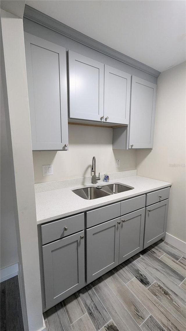 kitchen featuring sink, light hardwood / wood-style floors, and gray cabinetry