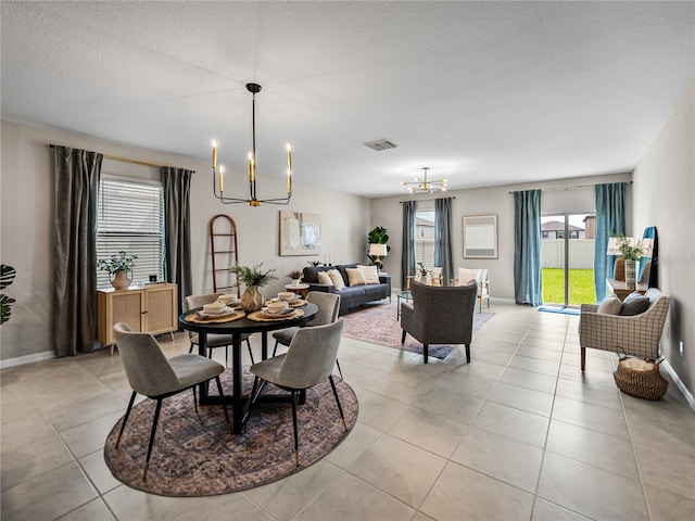 dining room featuring a chandelier, a textured ceiling, and light tile patterned floors