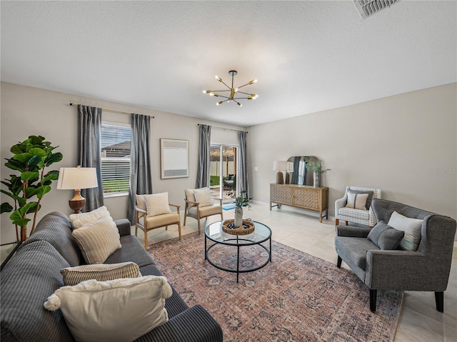 living room featuring a chandelier, a textured ceiling, and light tile patterned flooring