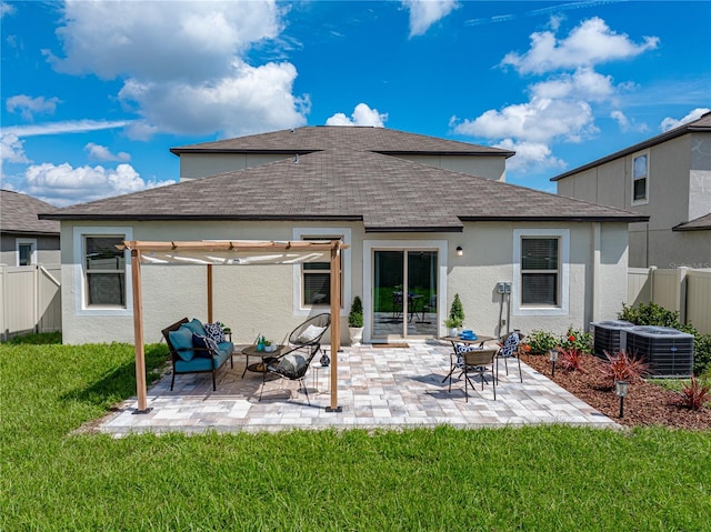 rear view of property featuring central AC unit, a patio area, and a yard