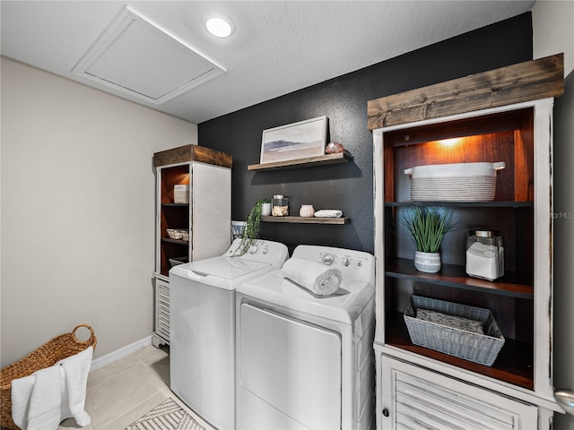 clothes washing area with light tile patterned floors, a textured ceiling, and independent washer and dryer