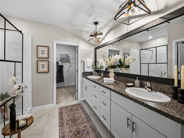 bathroom with a tile shower, tile patterned floors, and vanity