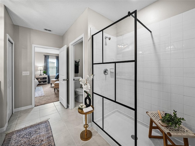 bathroom featuring a textured ceiling, toilet, an enclosed shower, and tile patterned floors