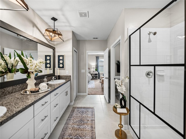 bathroom with vanity, a textured ceiling, an enclosed shower, and tile patterned floors