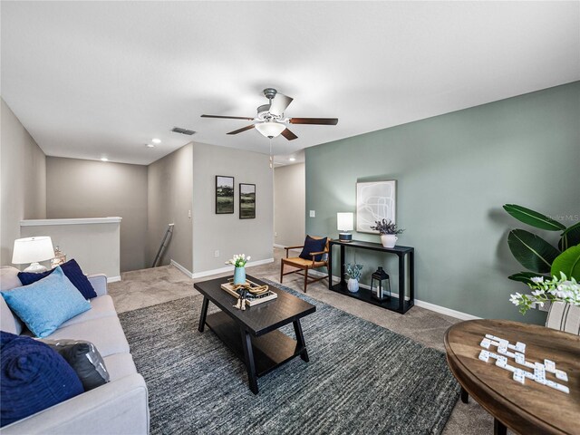 living room featuring dark colored carpet and ceiling fan