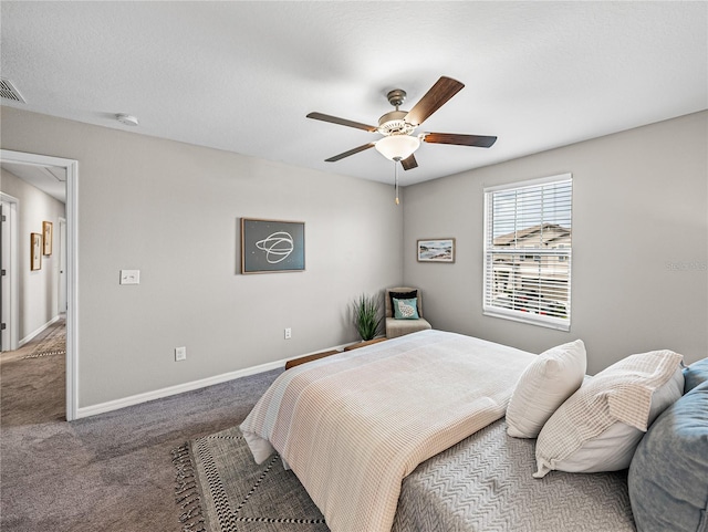 carpeted bedroom with ceiling fan and a textured ceiling