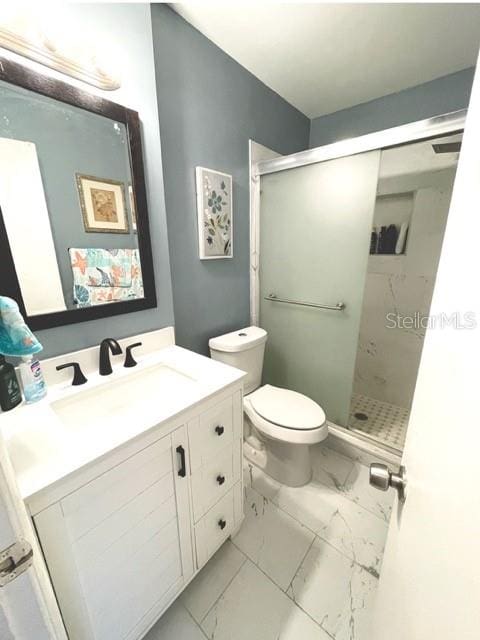 bathroom with toilet, tile patterned flooring, vanity, and a shower with shower door