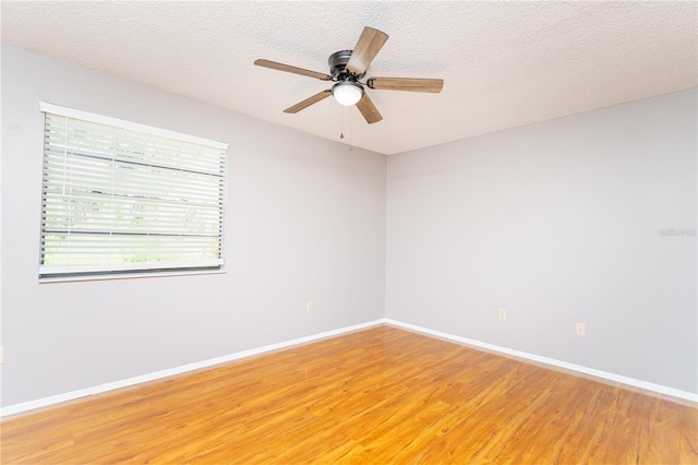 spare room with hardwood / wood-style floors, ceiling fan, and a textured ceiling