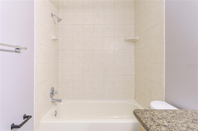 full bathroom featuring tiled shower / bath combo, vanity, and toilet