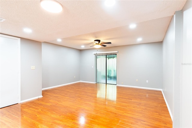 spare room with a textured ceiling, ceiling fan, and light hardwood / wood-style floors