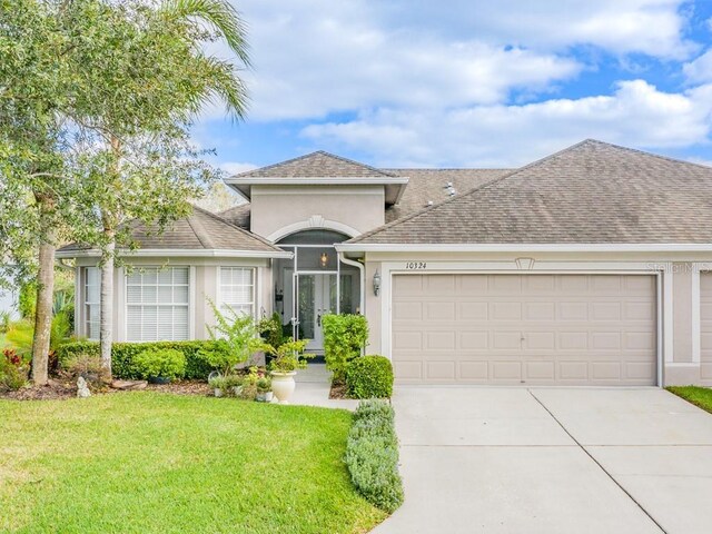 view of front of home with a garage and a front lawn