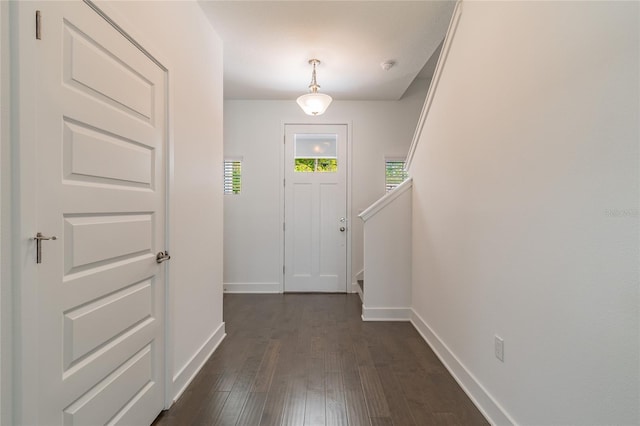 entryway with stairs, baseboards, and dark wood-style floors