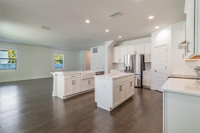 kitchen with white cabinets, a center island, dark wood-type flooring, and range