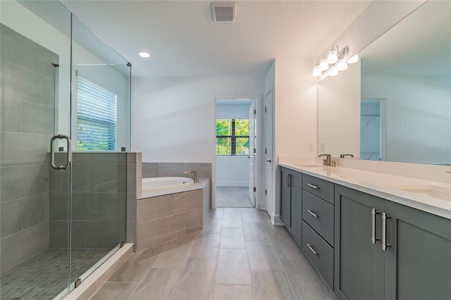 bathroom featuring tile patterned floors, independent shower and bath, and vanity