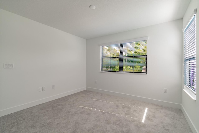 carpeted empty room with baseboards