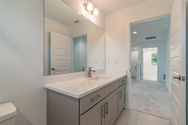 bathroom featuring toilet, tile patterned floors, visible vents, and vanity