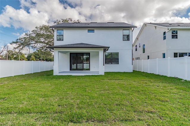 rear view of house with a patio area and a lawn