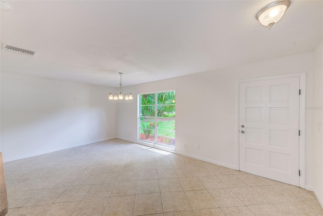 unfurnished room featuring a chandelier and light tile patterned flooring