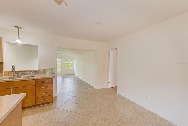 kitchen featuring ceiling fan, light tile patterned flooring, sink, and hanging light fixtures