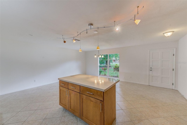 kitchen featuring pendant lighting, a kitchen island, light tile patterned floors, and track lighting