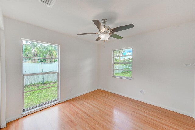 empty room with light wood-type flooring, plenty of natural light, and ceiling fan