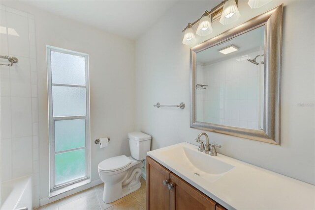 bathroom with tile patterned floors, plenty of natural light, vanity, and toilet