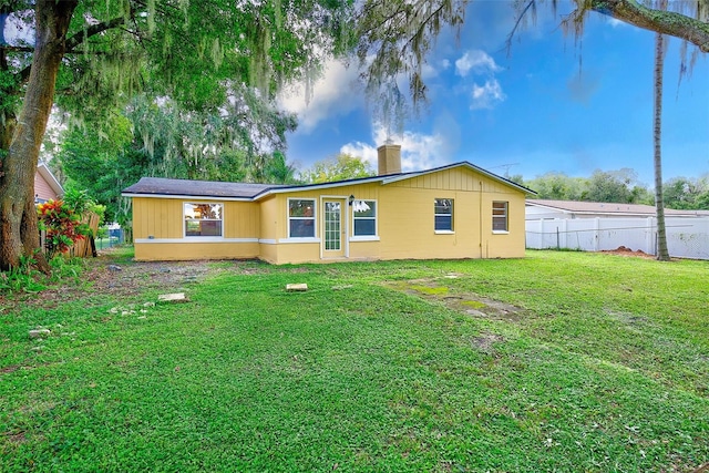 rear view of property with a lawn