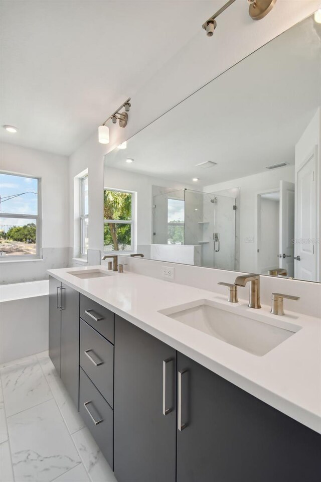 bathroom featuring tile patterned flooring, a healthy amount of sunlight, shower with separate bathtub, and vanity