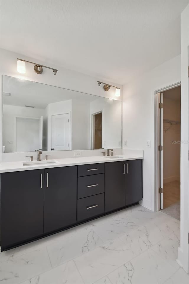 210 E Janette Ave, Tampa, FL 33603 - bathroom featuring marble finish floor, double vanity, a spacious closet, and a sink