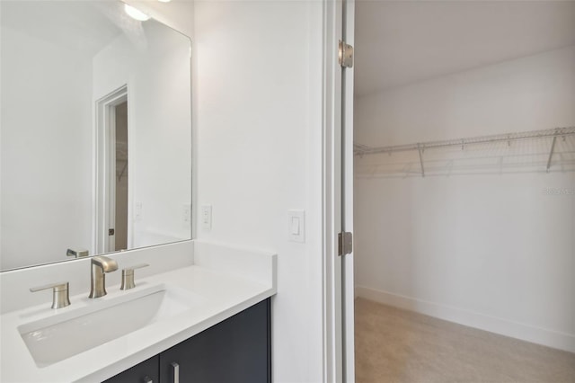 210 E Janette Ave, Tampa, FL 33603 - bathroom featuring a walk in closet, vanity, and baseboards