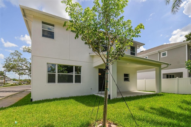 210 E Janette Ave, Tampa, FL 33603 - rear view of property featuring a yard, stucco siding, fence, and a patio