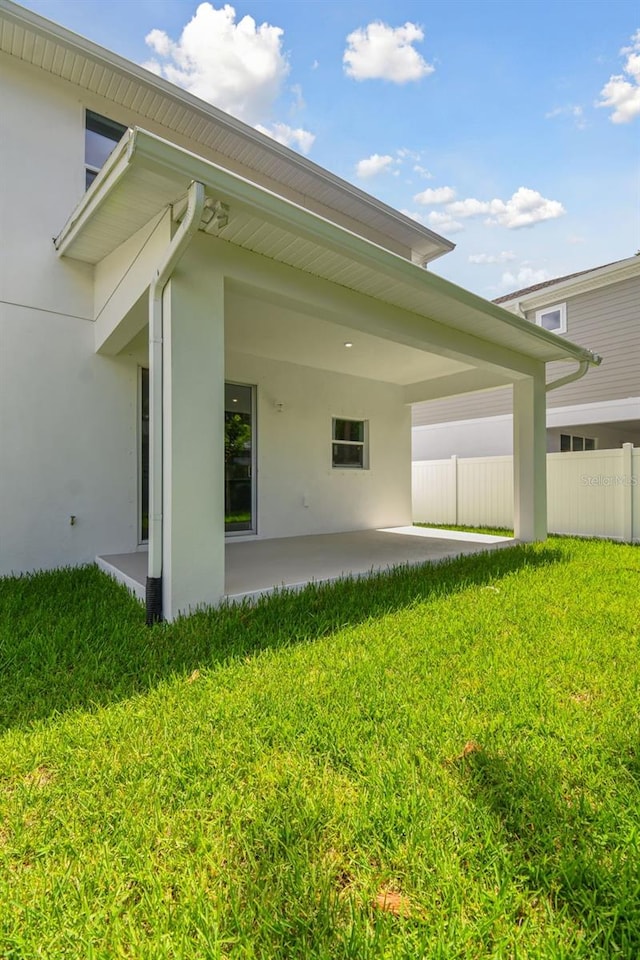 rear view of house with a lawn and a patio area