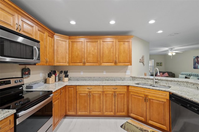 kitchen with sink, light tile patterned floors, light stone countertops, ceiling fan, and stainless steel appliances