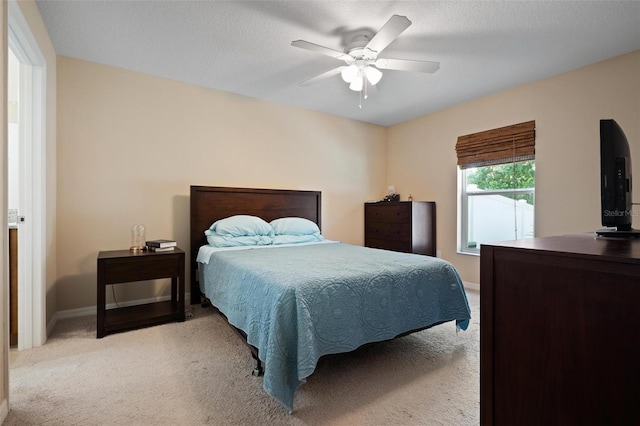 carpeted bedroom with ceiling fan and a textured ceiling