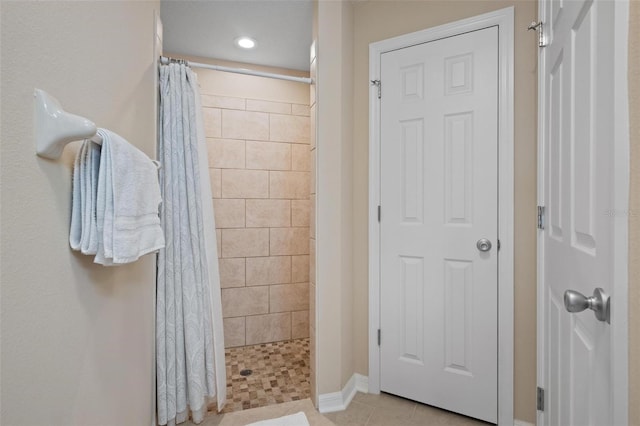 bathroom with walk in shower and tile patterned flooring