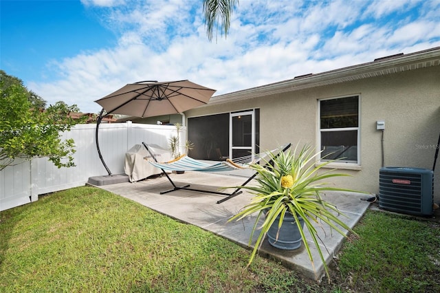 rear view of property featuring a lawn, a patio area, and central AC