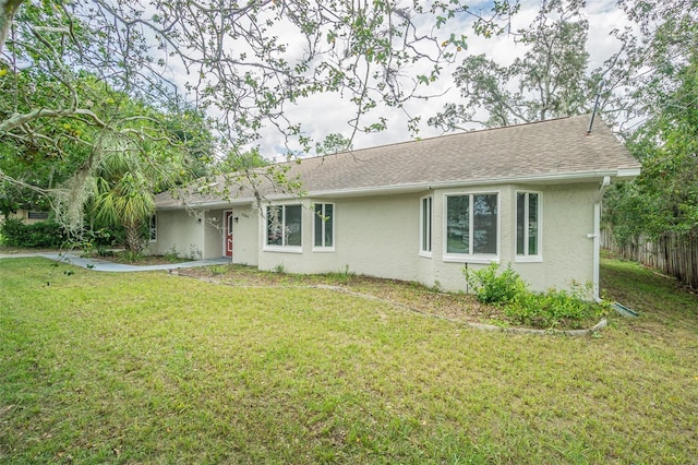 rear view of house featuring a yard