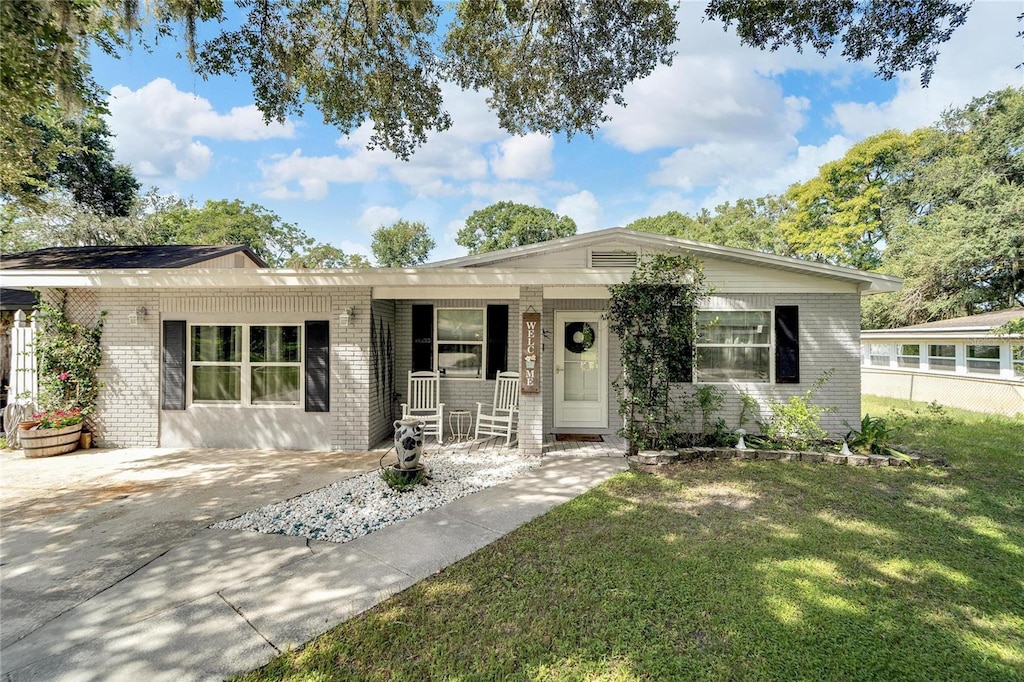 ranch-style home with covered porch and a front lawn