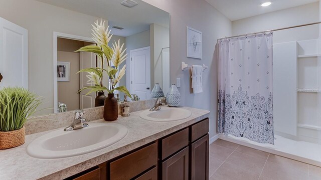 bathroom with dual bowl vanity and tile patterned floors