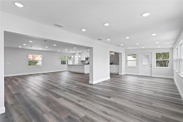 unfurnished living room with dark hardwood / wood-style floors and sink