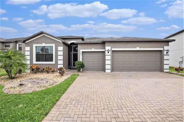 view of front of property featuring a garage, decorative driveway, and stucco siding