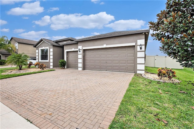 view of front facade with an attached garage, a front lawn, decorative driveway, and stucco siding