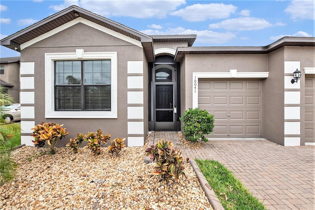 view of front of property with a garage, decorative driveway, and stucco siding