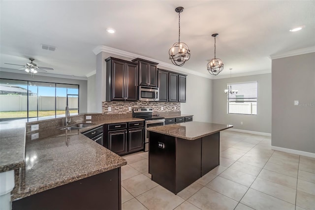 kitchen featuring a center island, stainless steel appliances, visible vents, decorative backsplash, and a sink