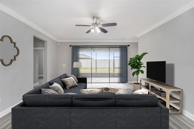 living room with a ceiling fan, crown molding, baseboards, and wood finished floors