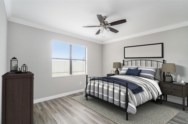 bedroom featuring crown molding, a ceiling fan, light wood-style flooring, and baseboards