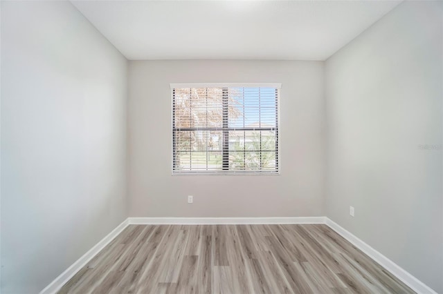 spare room with light wood-type flooring and baseboards