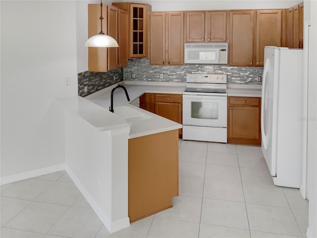 kitchen with light tile patterned flooring, sink, white appliances, tasteful backsplash, and kitchen peninsula