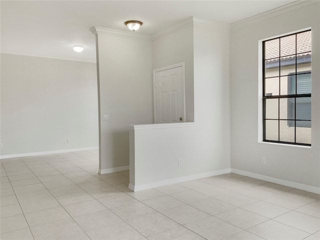 empty room with ornamental molding, baseboards, and light tile patterned floors